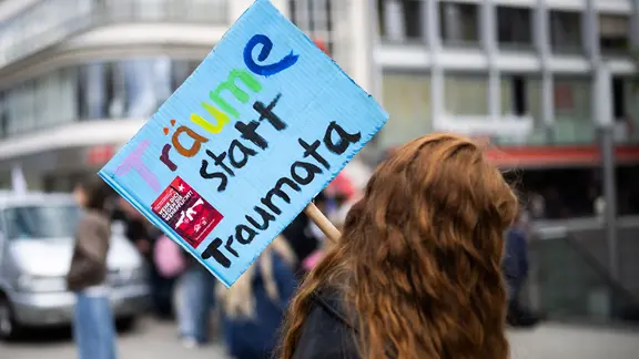 Hannover: Eine Teilnehmerin steht mit einem Plakat "Träume statt Traumata" bei einer Demonstration "Schulstreik gegen Wehrpflicht" in der Innenstadt. 