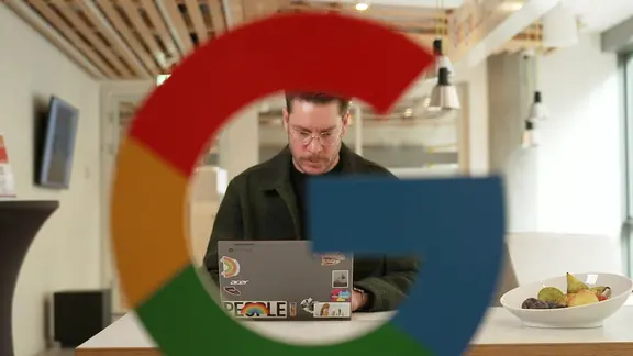 Google-Sprecher Philipp Gooding sitzt an seinem Laptop. | Screenshot Google-Sprecher Philipp Gooding sitzt an seinem Laptop.