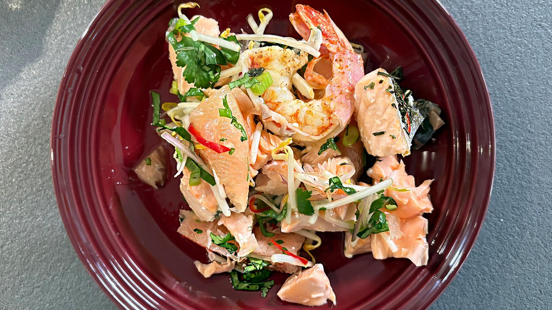 Lachsfilet mit Garnelen und Pomelosalat auf einem tiefen Teller angerichtet | Carsten Prehn