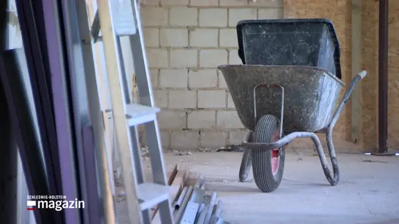 Eine beladene Schubkarre steht auf einer Baustelle