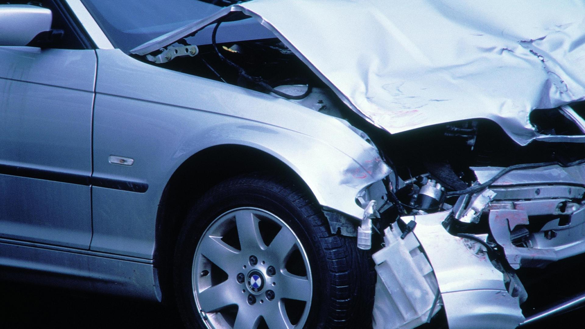 Ein silbernes Auto nach einem Verkehrsunfall mit eingedrückter Motorhaube. | picture alliance / VisualEyze, Janusz Pokorski
