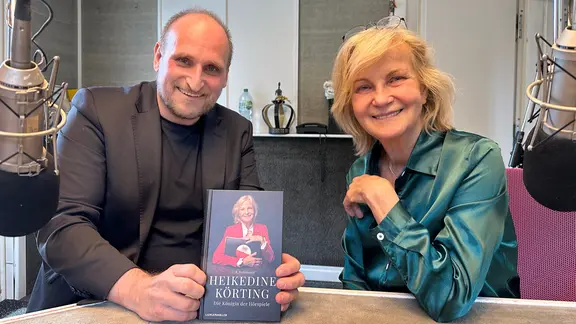 Daniel Kaiser und Heikedine Körting zeigen ein Buch