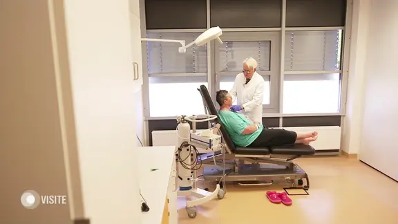 Eine Frau liegt auf einer Liege und wird von einem Arzt untersucht.