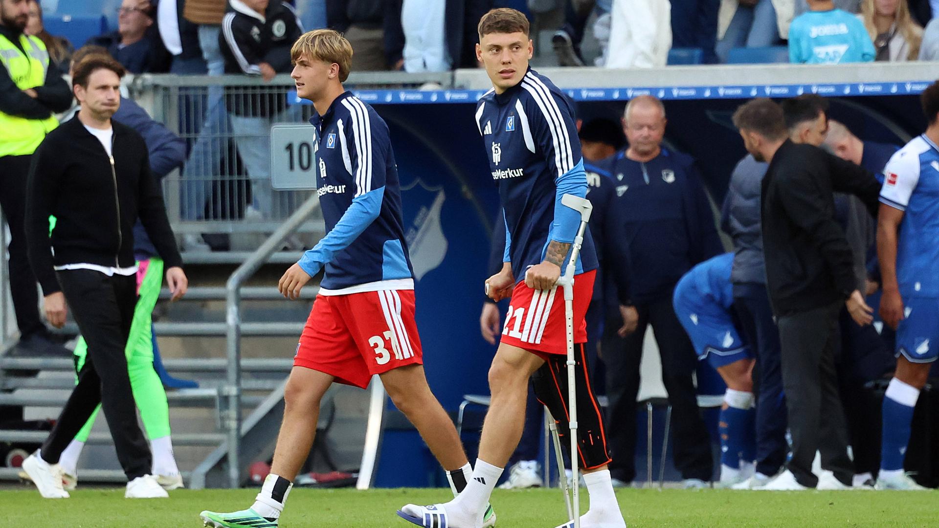 Kapitän Nicolai Remberg (r.) vom Hamburger SV verlässt auf Krücken den Platz in Sinsheim  | IMAGO / Jan Huebner