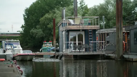 Ein Hausboot, fest vertäut an einem Steg.