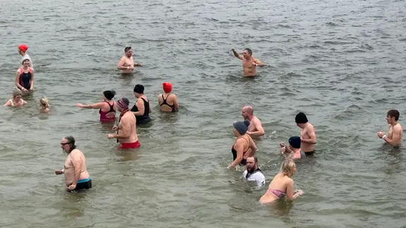 Mehrere Menschen baden in Olpenitz zu Neujahr in der Ostsee.
