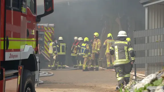 Einsatzkräfte der Feuerwehr bei Löscharbeiten auf einem Pferdehof in Melle.