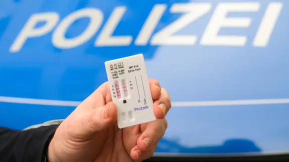 Ein Polizist zeigt einen Drogentest. (Themenbild)