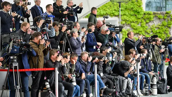 Fotografen und Kameraleute auf einer Pressetribüne vor dem Bundeskanzleramt. | dpa picture-alliance, Bernd von Jutrczenka Fotografen und Kameraleute auf einer Pressetribüne vor dem Bundeskanzleramt.