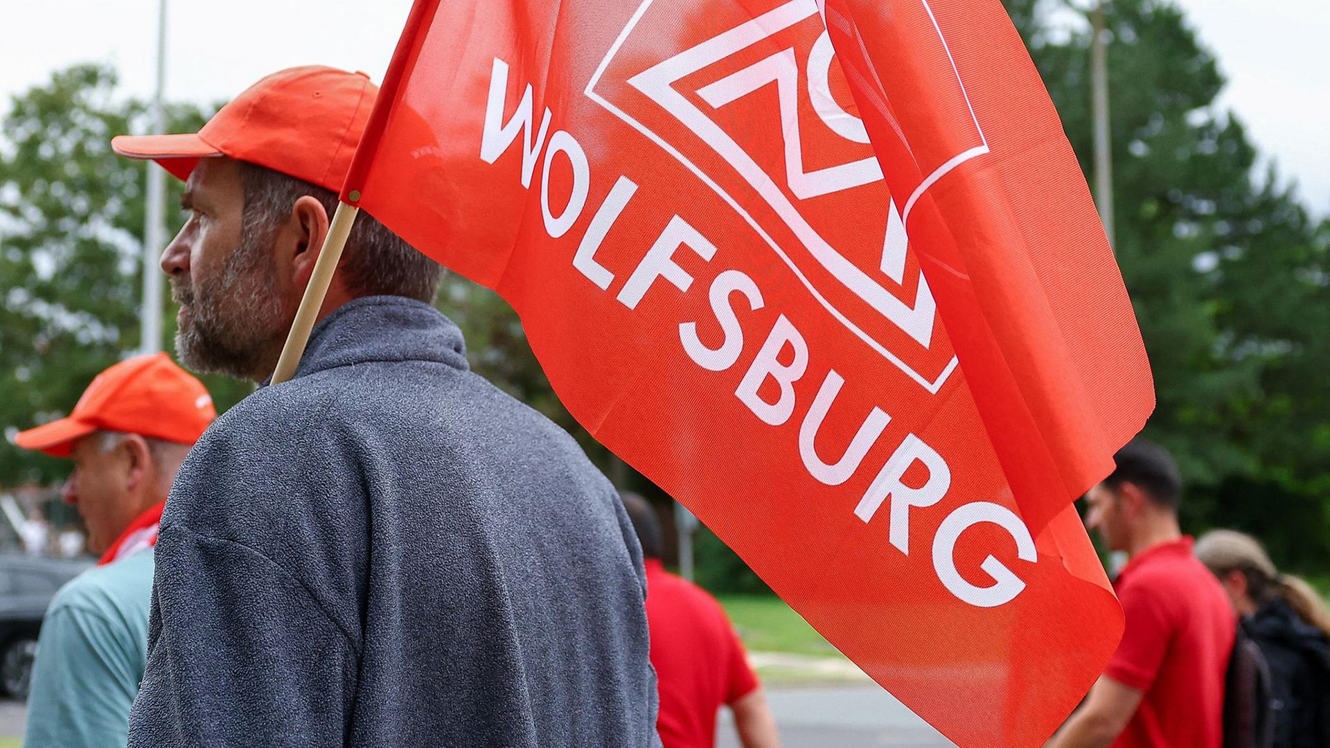 Mitarbeitende von Volkswagen beteiligen sich an einer Informations- und Protestaktion der IG Metall vor dem VW-Werk in Wolfsburg. | dpa, Lisi Niesner