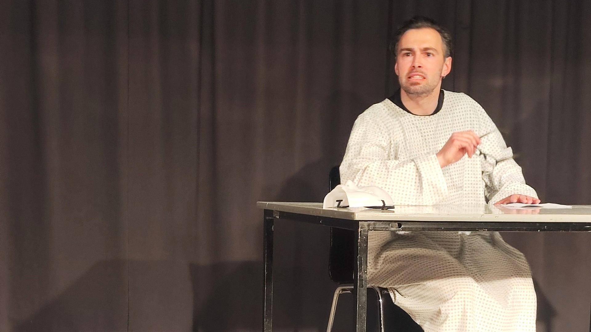 Steffen Hagemann sitzt im OP-Hemd an einem Tisch | NDR, Zarah-Louise Roth