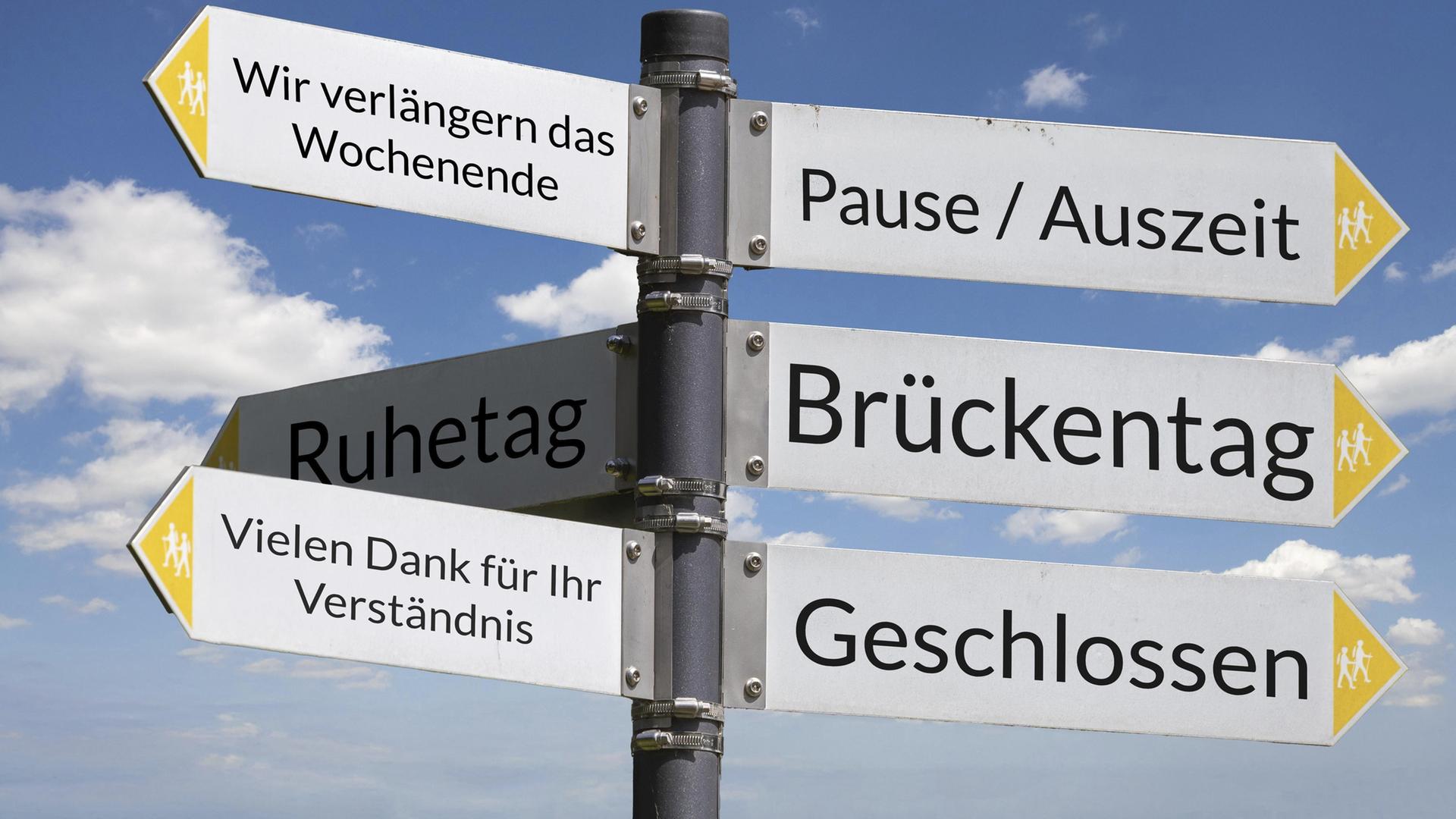 Freigestelltes Wanderschild vor blauem Himmel zeigt in verschiedene Richtungen mit Begriffen zum Thema Brückentag. | picture alliance / imageBROKER | Udo Herrmann