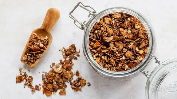 Ein Schraubglas mit Schoko-Granola, daneben eine kleine Schaufel mit Granola. | NDR, Claudia Timmann Ein Schraubglas mit Schoko-Granola, daneben eine kleine Schaufel mit Granola.