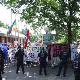 Menschen bei einer Demonstration. Sie halten Banner hoch, die sich gegen Faschismus richten.