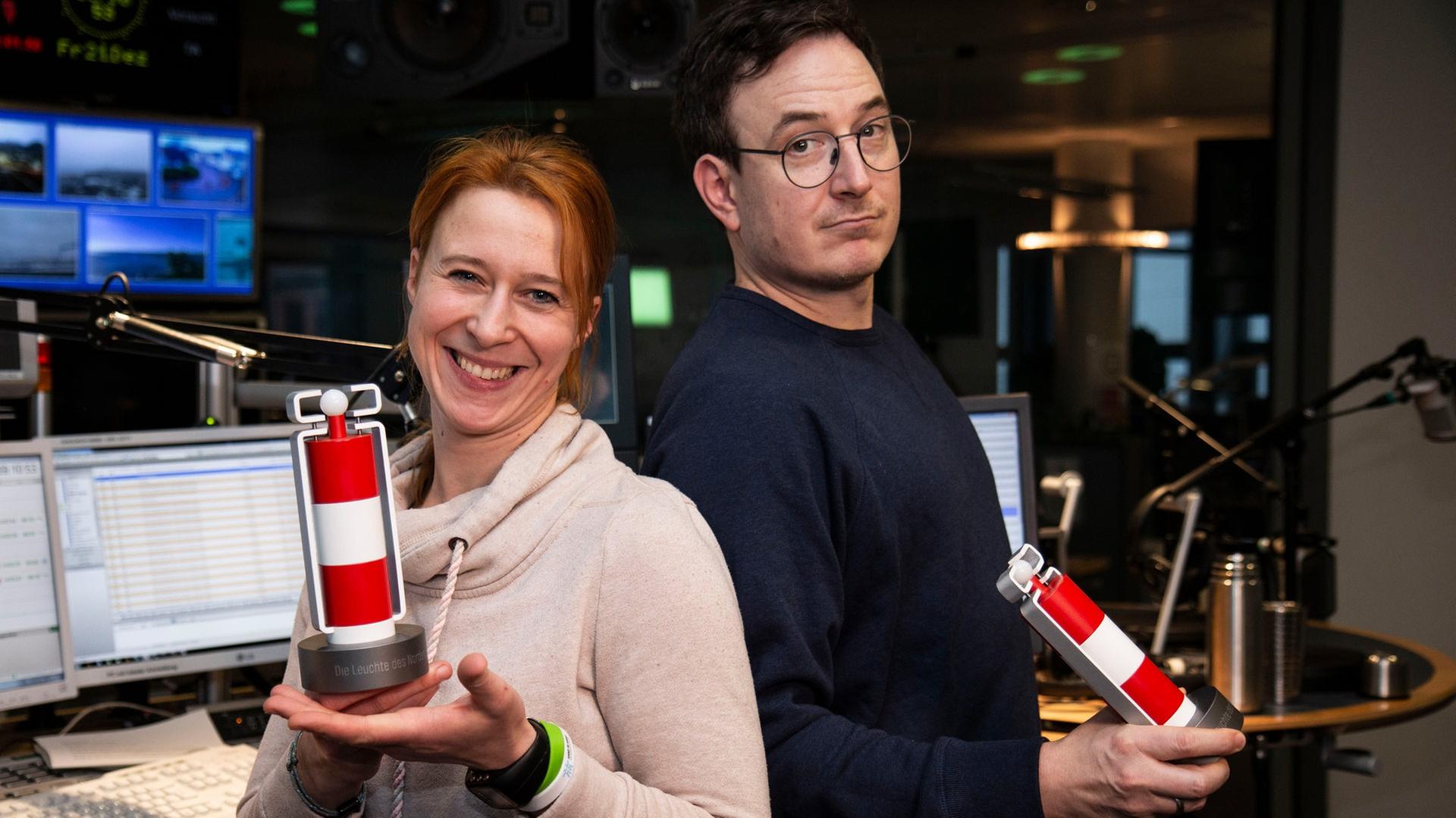 Das Moderatorenduo Mandy Schmidt und Horst Hoof posieren mit der 