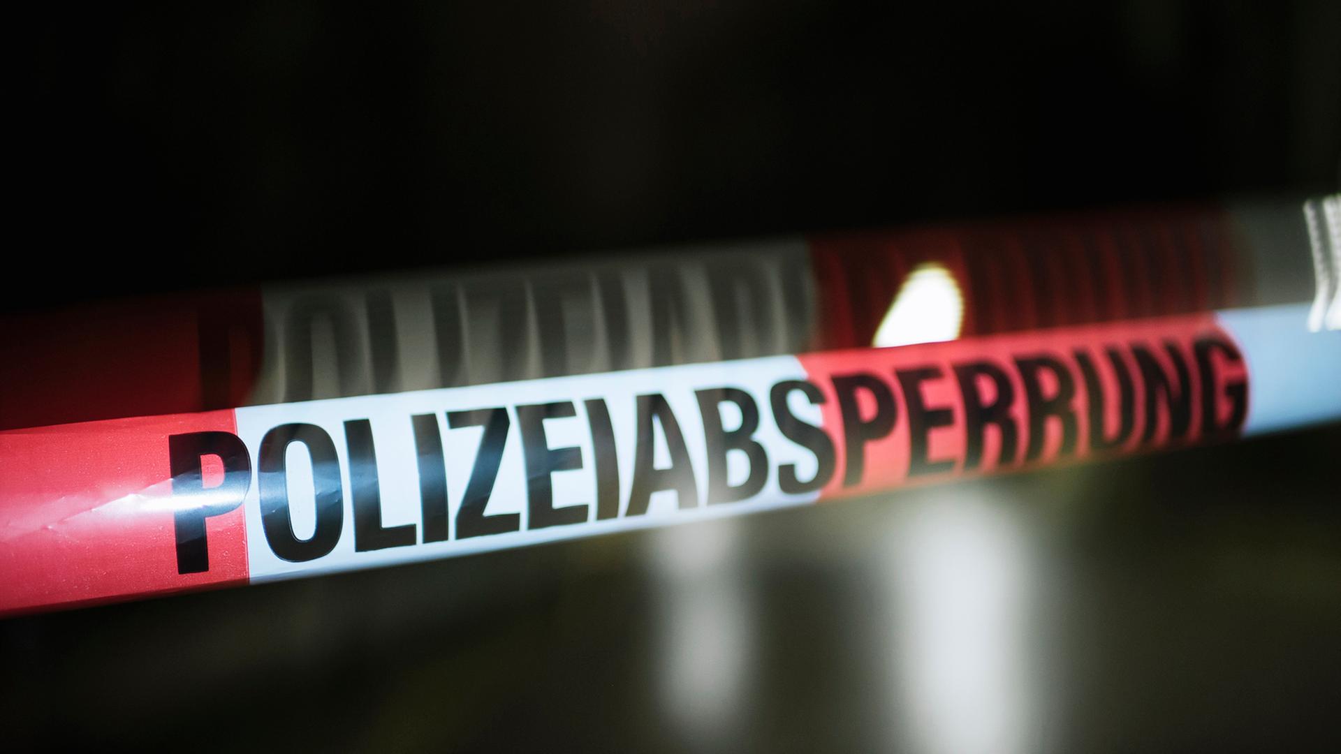 Ein Absperrband der Polizei vor dunklem Hintergrund bewegt sich im Wind, Bewegungsunschärfe. | NDR, Julius Matuschik