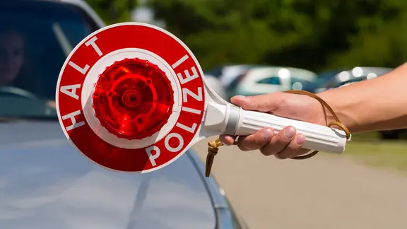 Eine Kelle der Polizei zeigt auf Halt