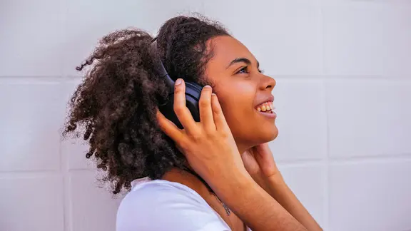 Frau hört über Kopfhörer Musik