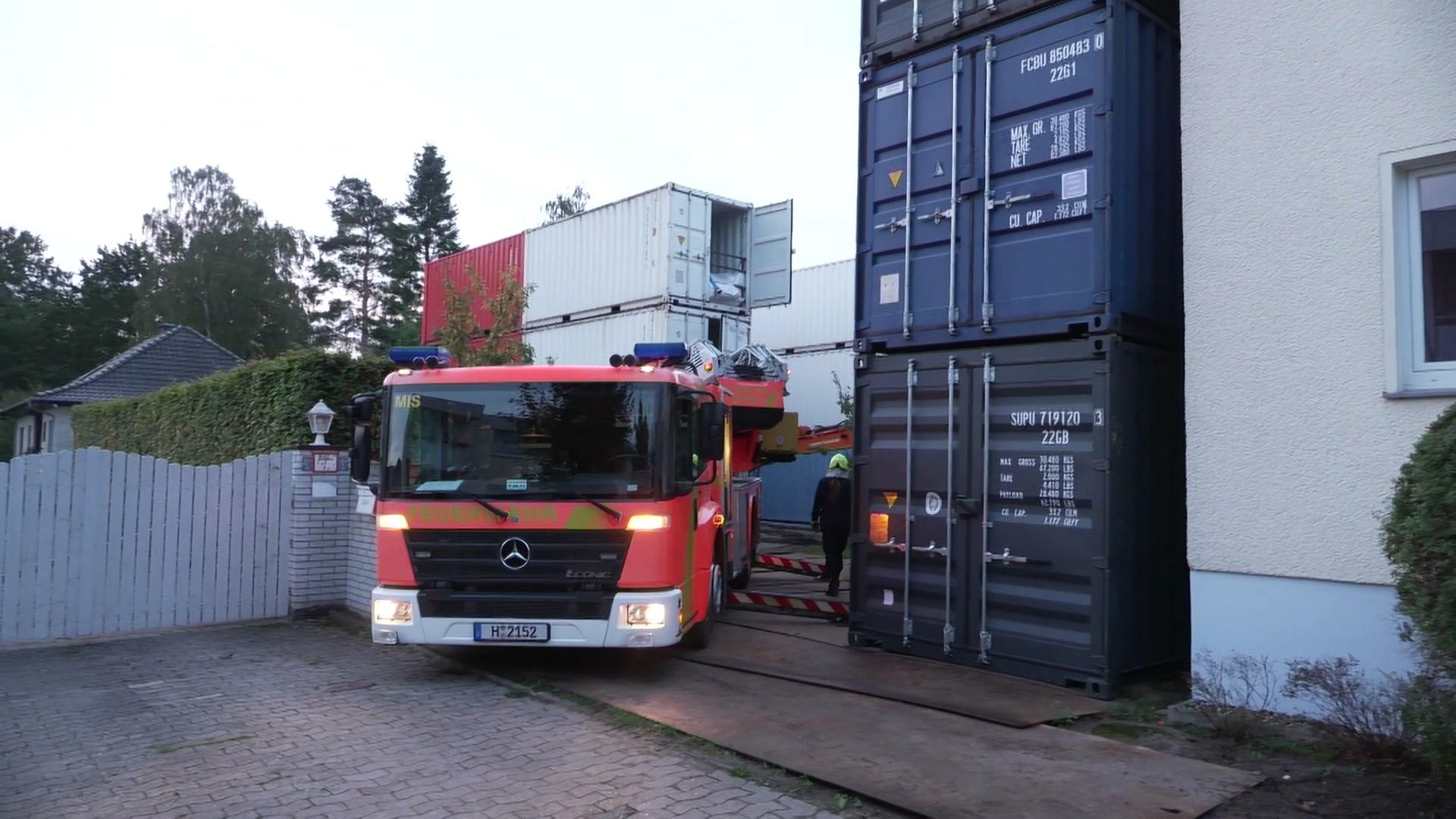 Ein Feuerwehrauto steht neben einer Containerburg in hannover-Misburg. | NWM NordWestMedia