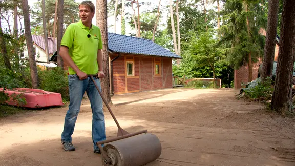 Damit die Samen Bodenkontakt haben, walzt Gärtner Rasch die Fläche mit einer Walze.