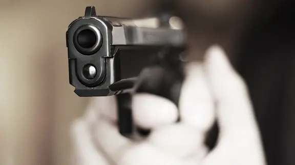 Eine Nahaufnahme von einer Pistole in den Händen einer Person