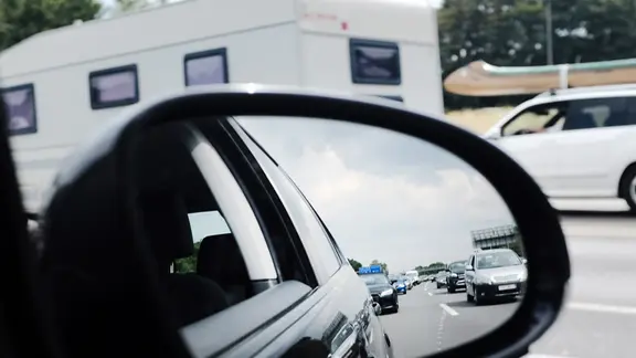 Im Außenspiegel eines Autos ist ein Stau auf der Autobahn zu sehen.