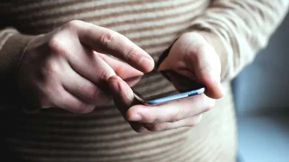 Person tippt auf dem Smartphone