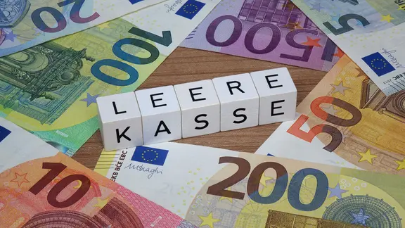  Auf verschiedenen Geldscheinen befinden sich Buchstabenwürfel mit dem Schriftzug "leere Kasse".