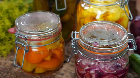 Pickles mit Blumenkohl, Gurken und Paprika in Gläsern