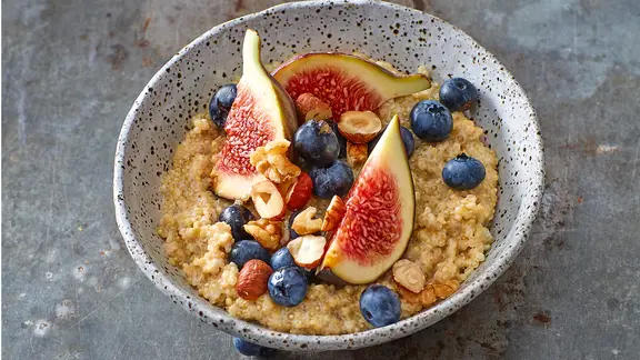 Eine Schale mit Quinoa-Brei, Heidelbeeren, Feigenspalten und Nüssen