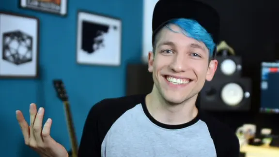 Rezo gestikuliert lächelnd in die Kamera.