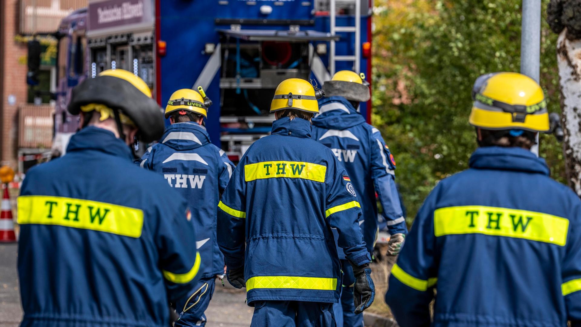Ehrenamtliche des THW laufen auf ein Einsatzfahrzeug zu. | picture alliance, Jochen Tack