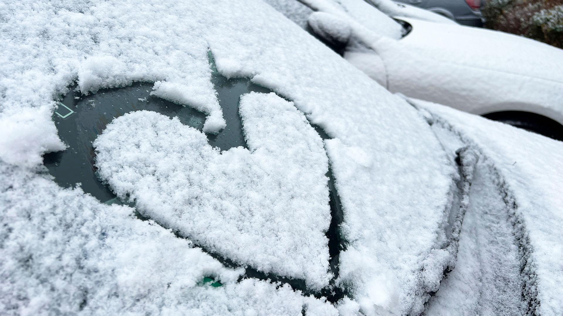 Ein Herz ist auf die schneebedeckte Windschutzscheibe eines Autos gemalt. | NDR, Marlene Kukral