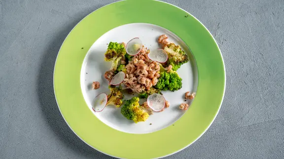 Gebratener Romanesco mit Nordseekrabben auf einem Teller serviert.