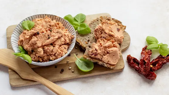 Ein Schälchen und zwei Scheiben Brot mit einem Tofuaufstrich auf einem Holzbrettchen. | NDR, Claudia Timmann Ein Schälchen und zwei Scheiben Brot mit einem Tofuaufstrich auf einem Holzbrettchen.