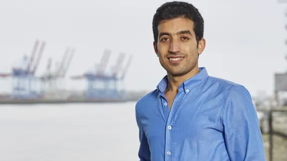 Faisal Hamdo steht im Hamburger Hafen.