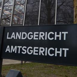 Ein schwarzes Schild mit dem Schriftzug "Landgericht Amtsgericht" steht vor dem Gebäude des Land- und Amtgerichts in Lübeck.