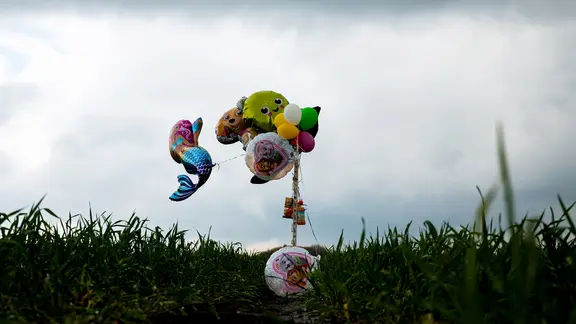 Bremervörde: Luftballons und Süßigkeiten hängen zur Hilfe bei der Suche nach einem vermissten Jungen auf einem Feld.