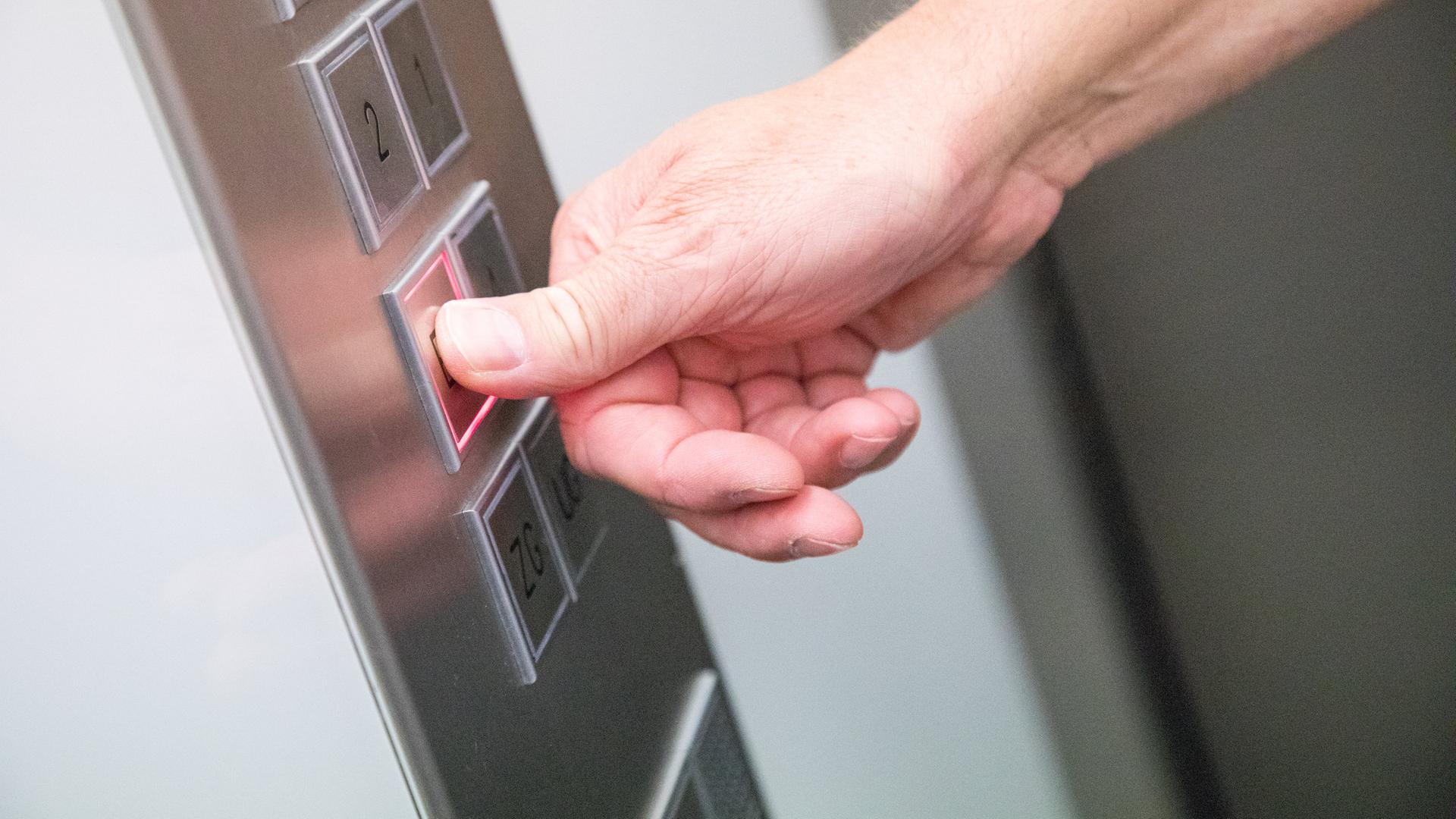 Eine Person drückt einen Knopf in einem Aufzug | Christin Klose/dpa-tmn/dpa