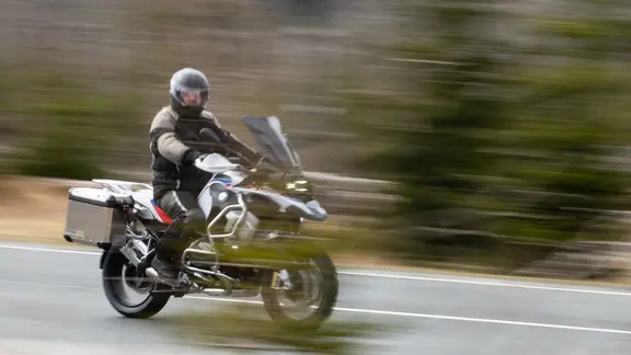 Ein Motorradfahrer fährt an der Kamera im Harz vorbei.