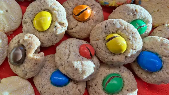 Mehrere Kekse, die jeweils mit einer Schokolinse verziert sind.