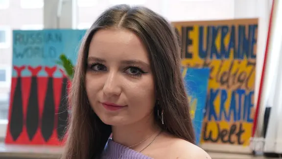 Eine Frau blickt frontal in die Kamera