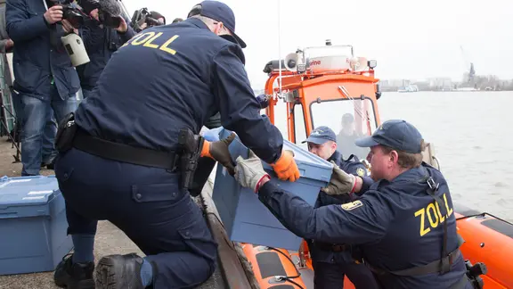 Zöllner laden Kisten mit Kokain von einem Rettungsboot im Hamburger Hafen