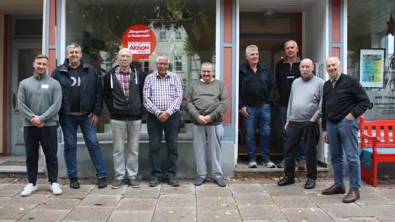 Teilnehmer der "Männerrunde" stehen vor einem Haus.