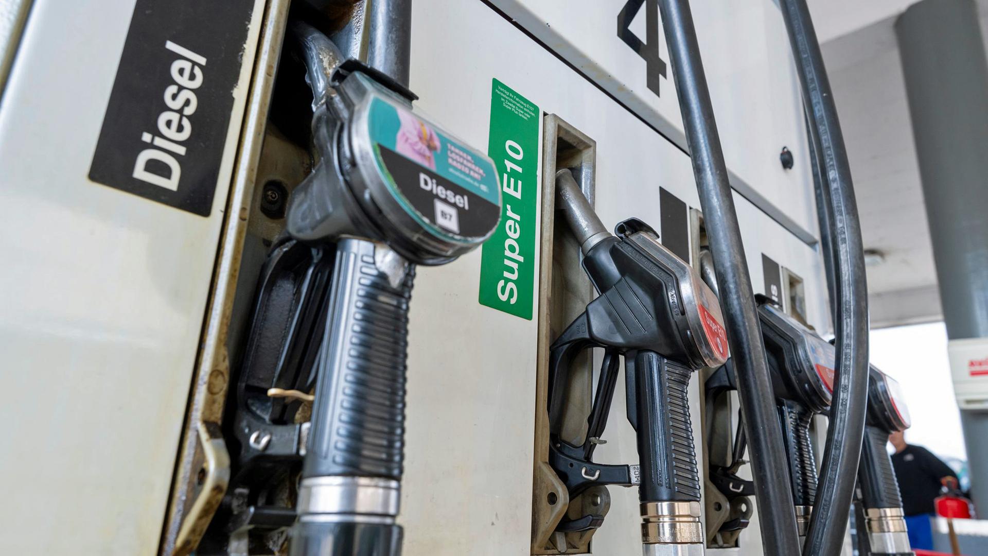Zapfpistolen für Kraftstoff hängen an einer Tankstelle in der Halterung. | dpa, Peter Kneffel