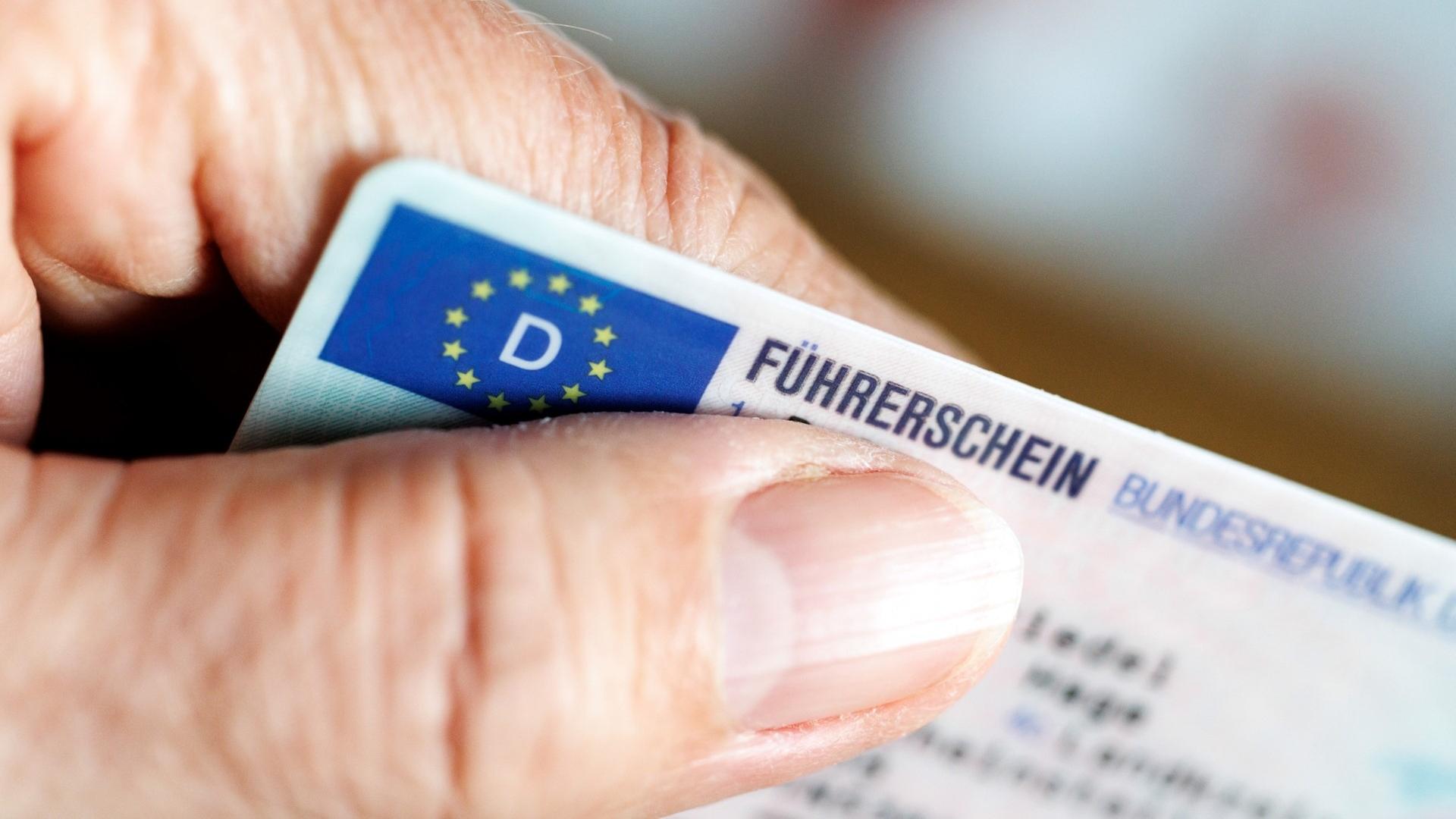 Eine Hand, die einen Führerschein festhält.  | picture alliance / dpa | Matthias Balk
