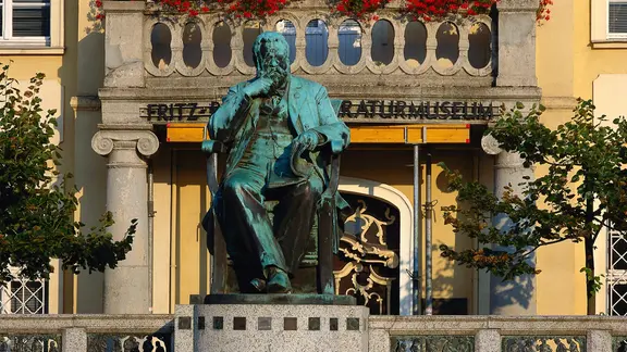 Vor dem Fritz-Reuter-Literaturmuseum in Stavenhagen steht ein Denkmal des Schriftstellers.