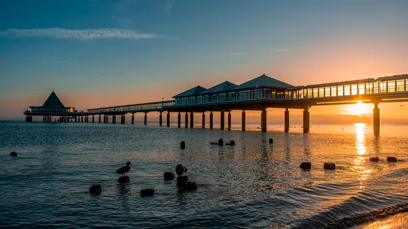 El muelle en Heringsdorf en Usedom visto desde la playa al atardecer