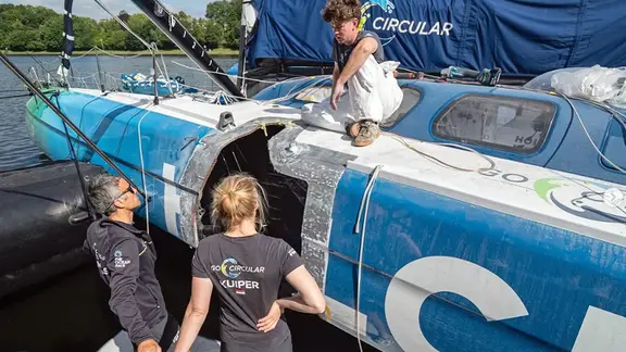 Skipperin Rosie Kuiper begutachtet die ersten Reparaturergebnisse am Rumpf der Holcim-Yacht.