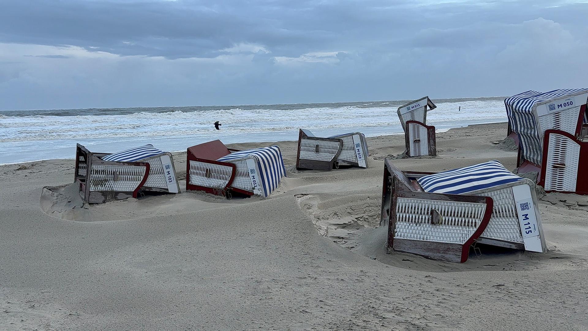 Umgestürzte Strandkörbe liegen am Strand von Norderney. | Volker Bartels, dpa